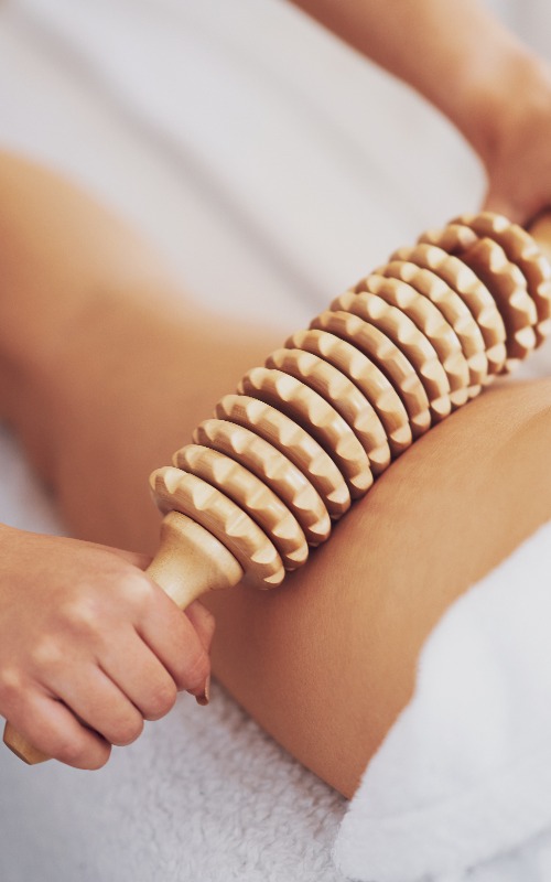 Frau bei der Massagetherapie mit Holzwerkzeugen