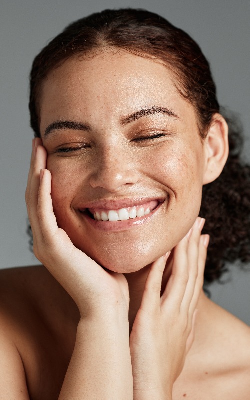 Gesicht, Schönheit und Zufriedenheit einer schwarzen Model-Frau im Studio vor grauem Hintergrund zur Werbung für natürliche Hautpflege. Gesichtspflege, Wellness und Make-up mit einer attraktiven jungen Frau, die mit Kosmetikprodukten zufrieden ist
